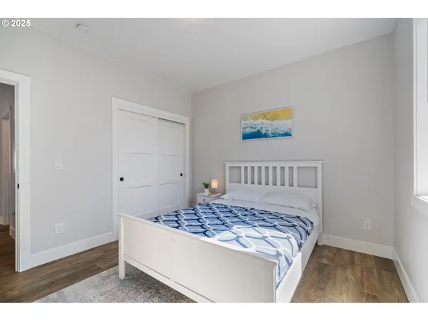 a bedroom with a bed and a painting on the wall