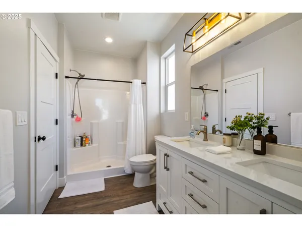 a bathroom with a double vanity sink toilet and shower