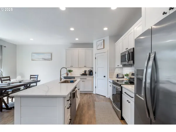 a kitchen with kitchen island a sink stainless steel appliances and cabinets