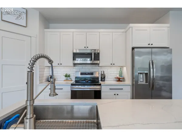 a kitchen with stainless steel appliances granite countertop a refrigerator and a stove top oven
