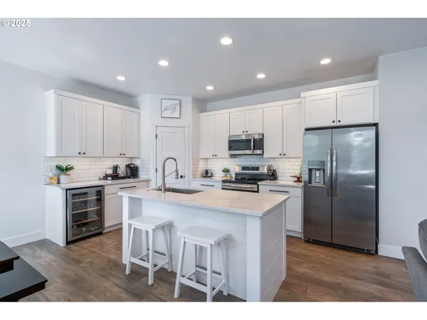 a kitchen with kitchen island a sink stainless steel appliances and cabinets