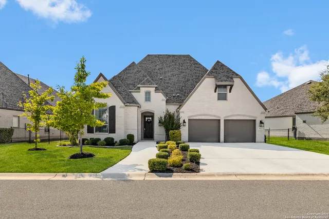 a front view of a house with a yard and potted plants