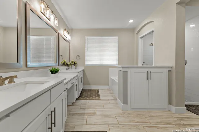 a spacious bathroom with a double vanity sink and a mirror
