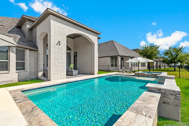 a front view of a house with swimming pool having outdoor seating