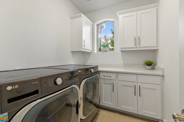 a utility room with cabinets and a wooden floor