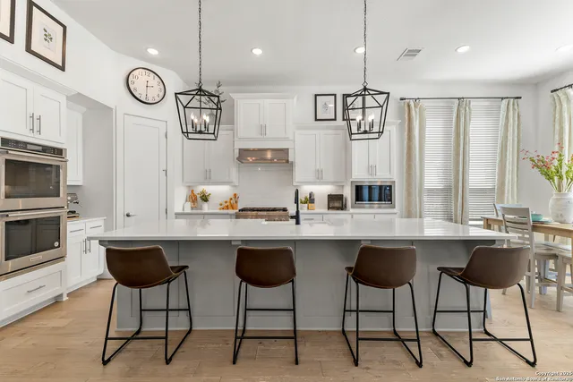 a kitchen with stainless steel appliances granite countertop a sink and a refrigerator