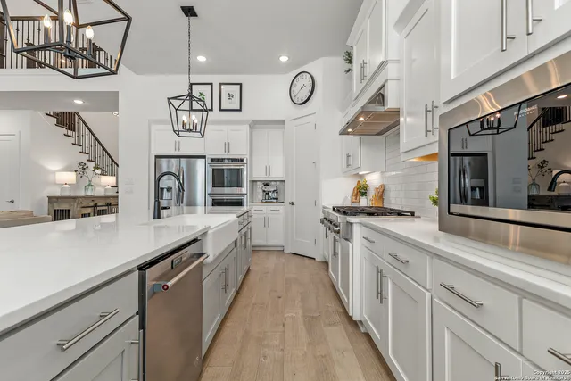 a large kitchen with stainless steel appliances lots of counter space and a sink