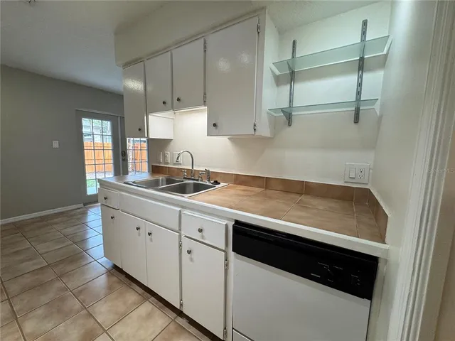 a kitchen with granite countertop white cabinets and a sink