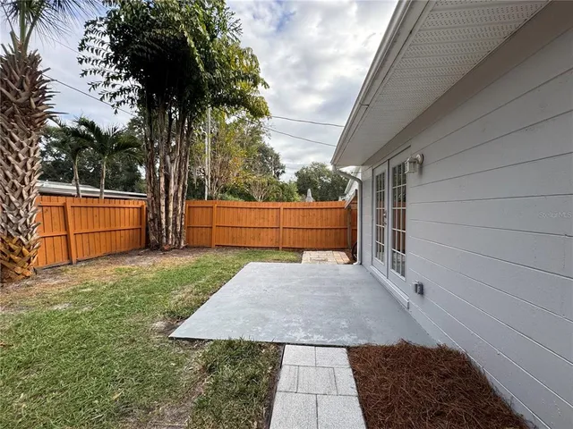 a view of backyard of house with wooden fence