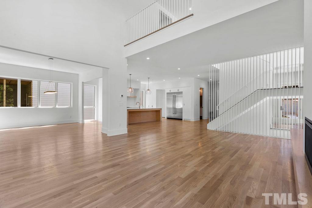 1623 Nottingham Road Raleigh, NC 27607 - Photo 2 of 29 a view of an empty room with wooden floor and a kitchen view