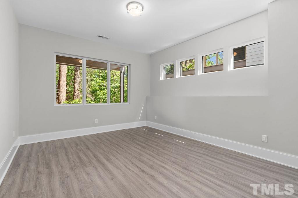 1623 Nottingham Road Raleigh, NC 27607 - Photo 12 of 29 a view of an empty room with wooden floor and a window