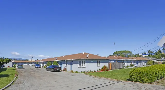 a view of a big house with a big yard and large trees