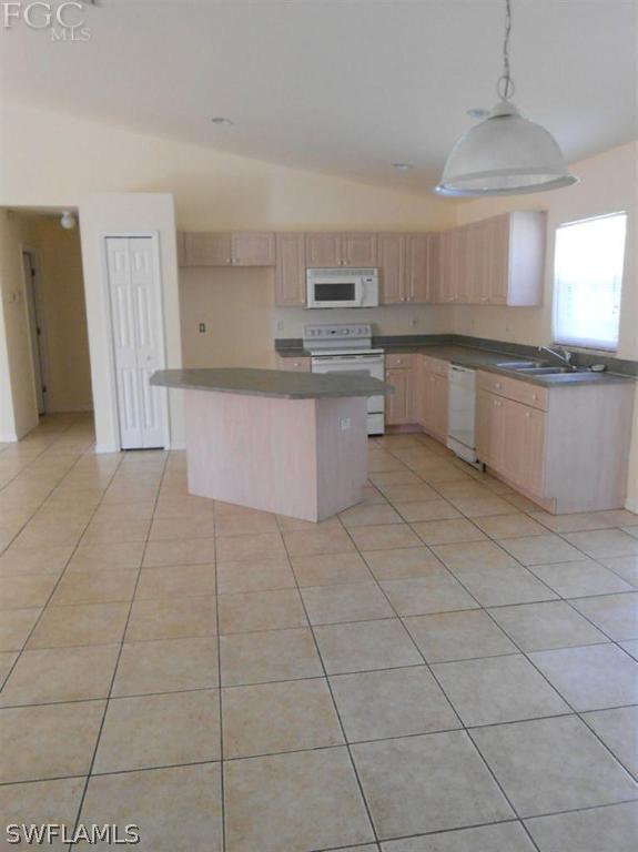 221 Rue Labonne Road Fort Myers, FL 33913 - Photo 3 of 10 a large kitchen with granite countertop a stove a sink and a refrigerator