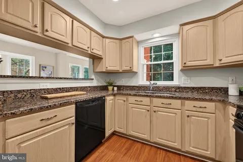 a kitchen with granite countertop cabinets stainless steel appliances and a sink