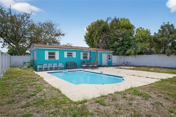 a view of a house with pool and sitting area