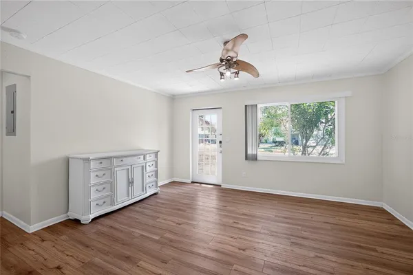 a view of an empty room with window and wooden floor