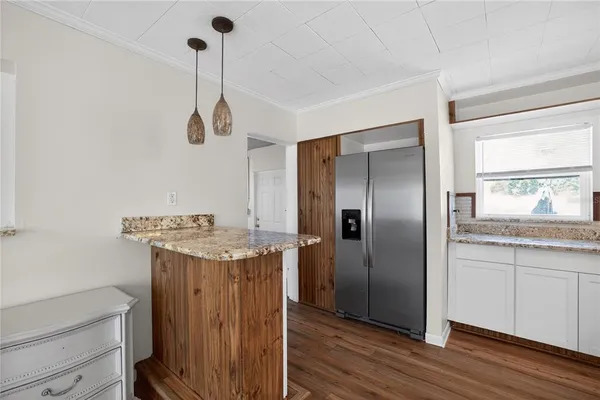 a room with a chandelier fan and wooden floor