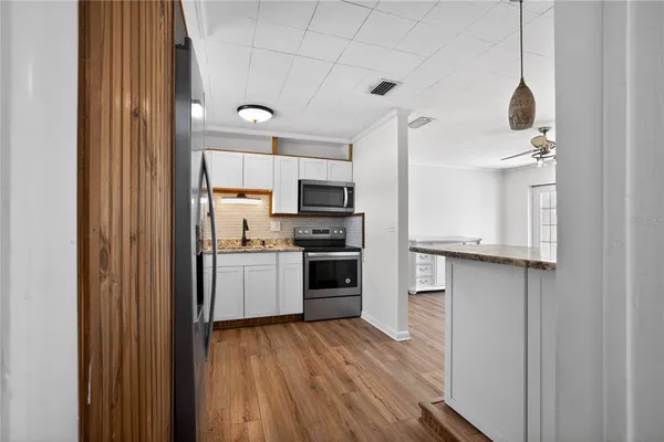 a kitchen with a refrigerator a stove top oven a sink and dishwasher with wooden floor