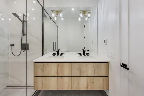 a bathroom with a double vanity sink a mirror and shower