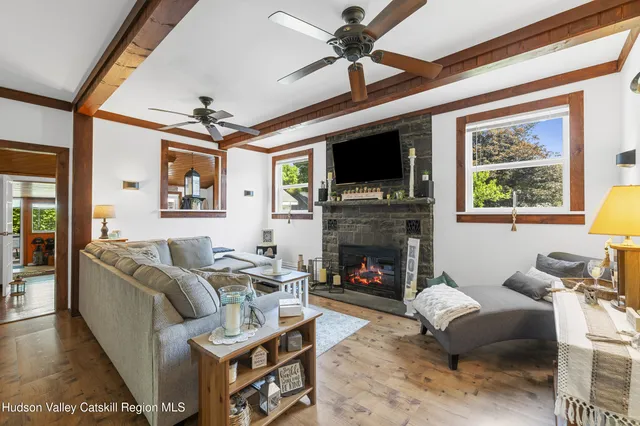 a living room with furniture a fireplace and a flat screen tv