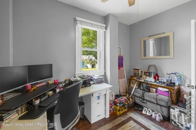 a view of a workspace with furniture and a window
