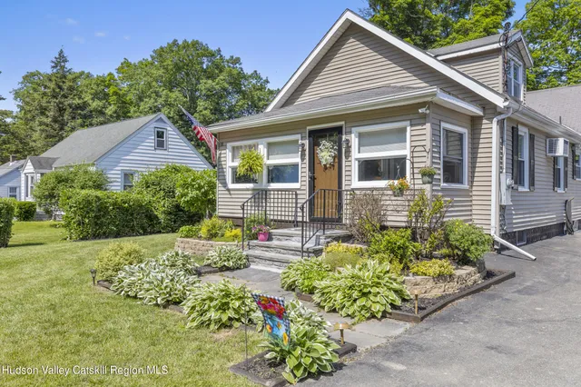 a front view of a house with a yard and potted plants