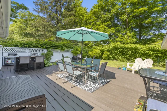 a view of a roof deck with table and chairs under an umbrella