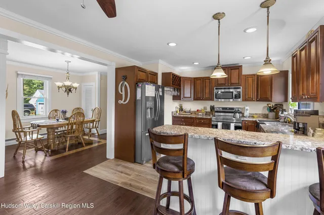 a kitchen with refrigerator and chairs