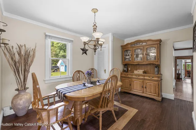 a dining room with furniture a chandelier and wooden floor
