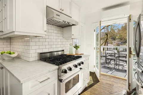 a kitchen with a stove and a wooden floor