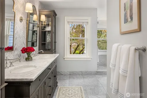 a bathroom with a granite countertop sink and a bathtub
