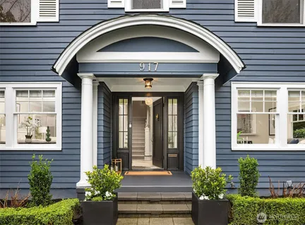 a front view of a house with potted plants
