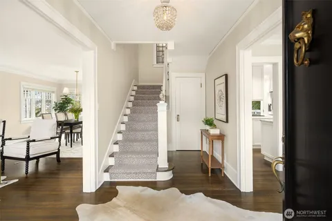 a view of a hallway with wooden floor and staircase
