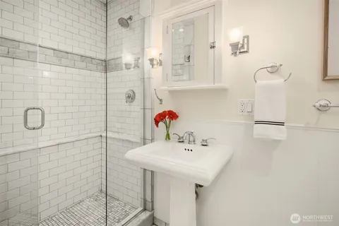 a bathroom with a sink shower and a mirror