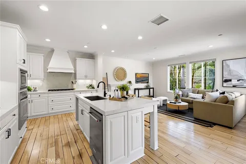 a large kitchen with kitchen island white cabinets and stainless steel appliances