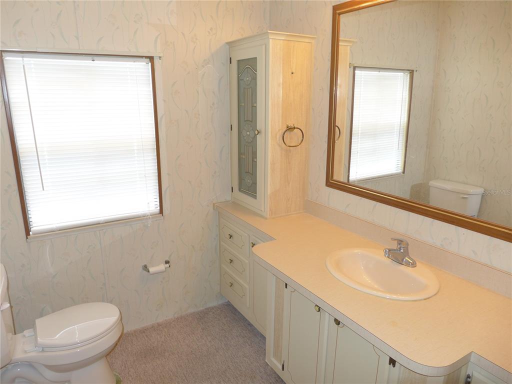 432 Santa Fe Road Tavares, FL 32778 - Photo 20 of 41 a bathroom with a sink a toilet and a mirror