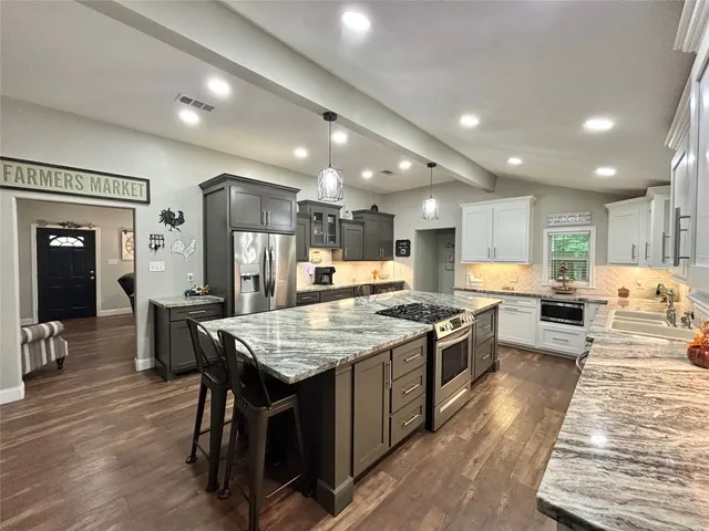 a large kitchen with a table and chairs