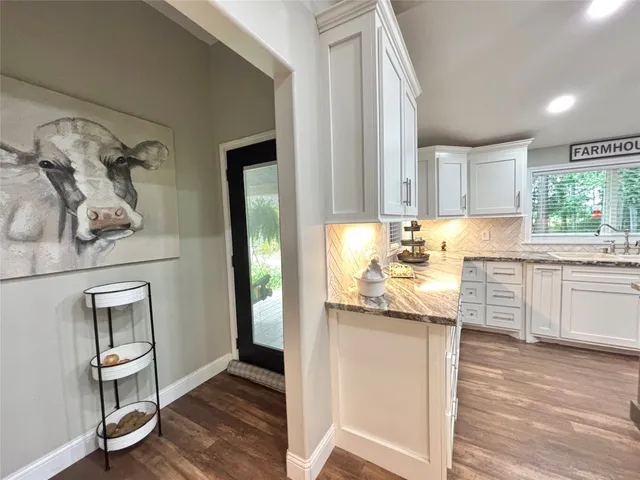 a kitchen with granite countertop white cabinets and white appliances