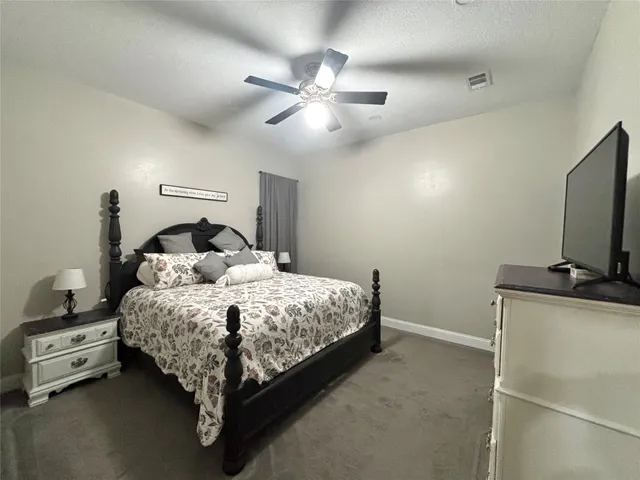 a bedroom with a bed and a flat tv screen on the dresser