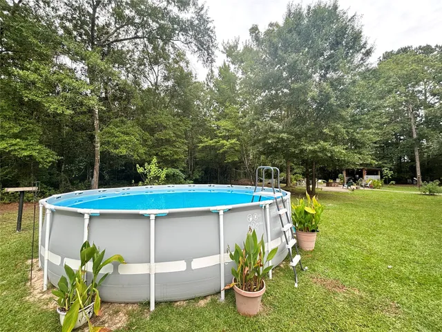 a view of a patio with table and chairs potted plants and large tree