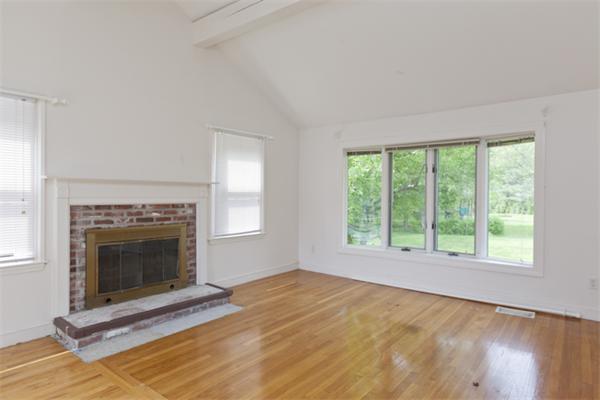 57 Concord Road Wayland, MA 01778 - Photo 4 of 10 a view of empty room with wooden floor and fireplace
