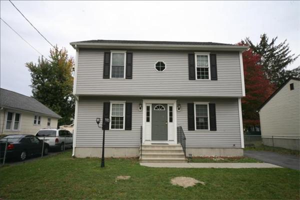 a front view of a house with a garden