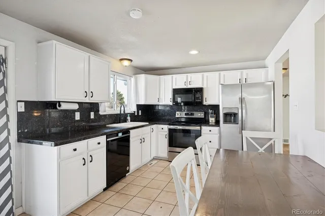 a kitchen with stainless steel appliances kitchen island granite countertop a refrigerator and a stove top oven