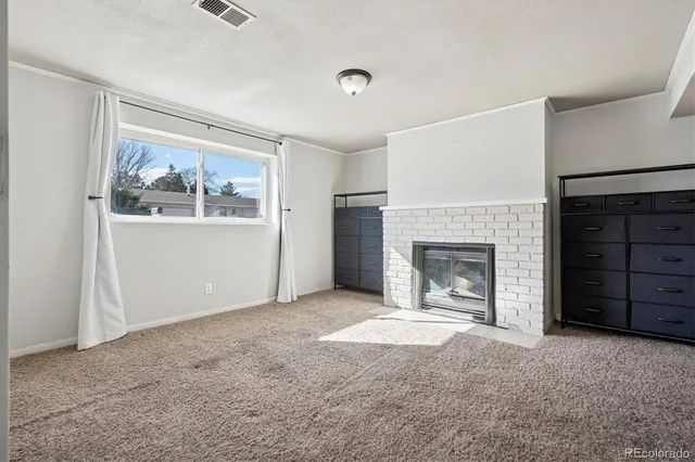 a view of a livingroom with a fireplace cabinet and window