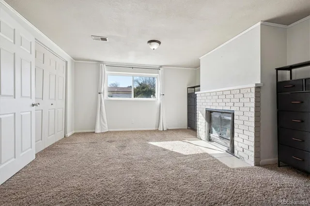 a view of an empty room with window and fireplace