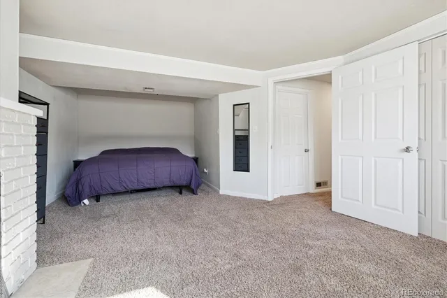 a view of an empty room with a fireplace and a window
