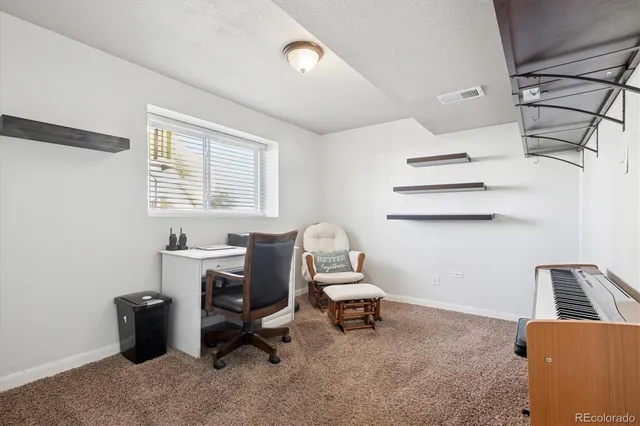 a view of a workspace with furniture and a window