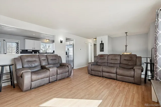 a living room with furniture and a wooden floor