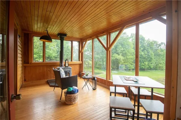 a dining room with wooden floor a chandelier a glass table and chairs