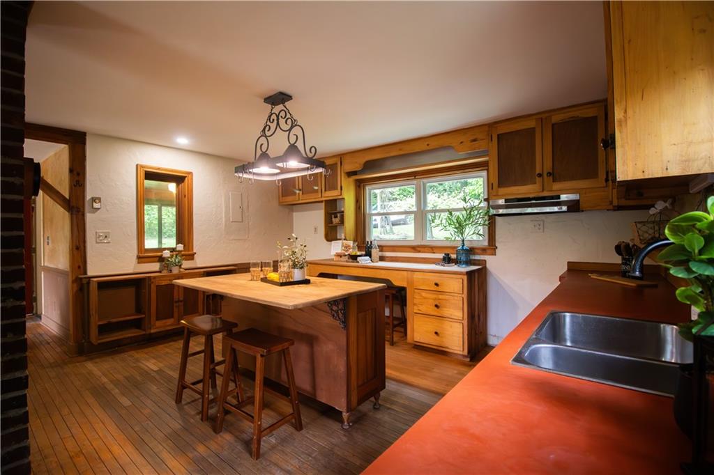 55 Elm St Extension Stoneboro, PA 16153 - Photo 26 of 44 a kitchen with a stove a sink dishwasher and a dining table with garden view